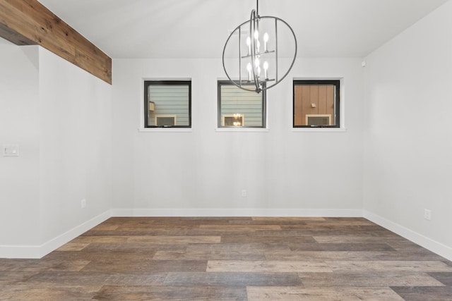 empty room featuring beamed ceiling, dark hardwood / wood-style floors, and an inviting chandelier