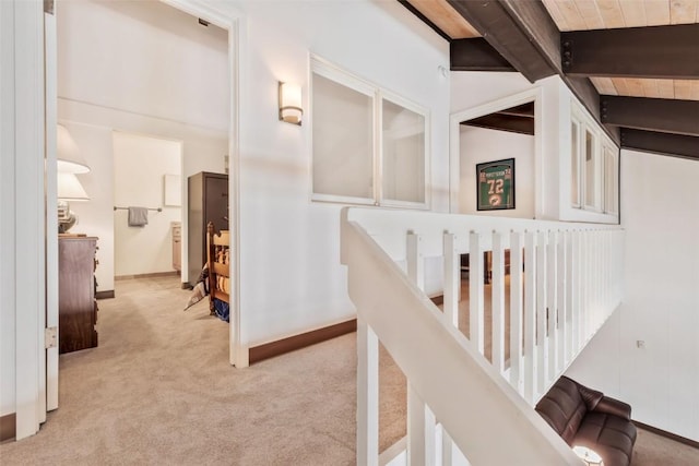 corridor with light carpet and vaulted ceiling with beams