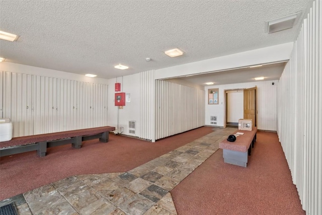 playroom with a textured ceiling and dark carpet