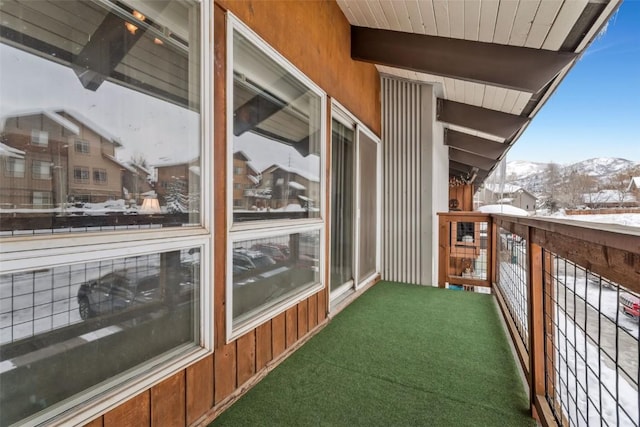 snow covered back of property featuring a mountain view