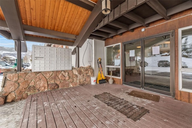 snow covered deck with a mountain view and a mail area