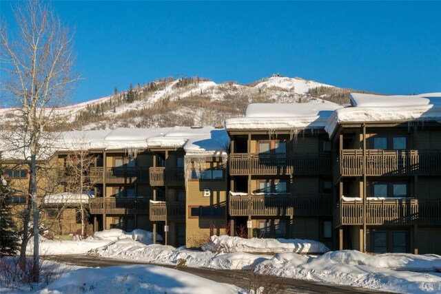 snow covered building featuring a mountain view