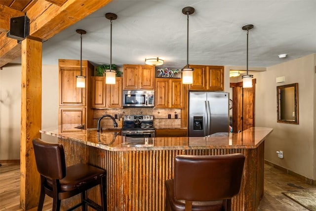 kitchen with a kitchen bar, brown cabinets, tasteful backsplash, stainless steel appliances, and a peninsula