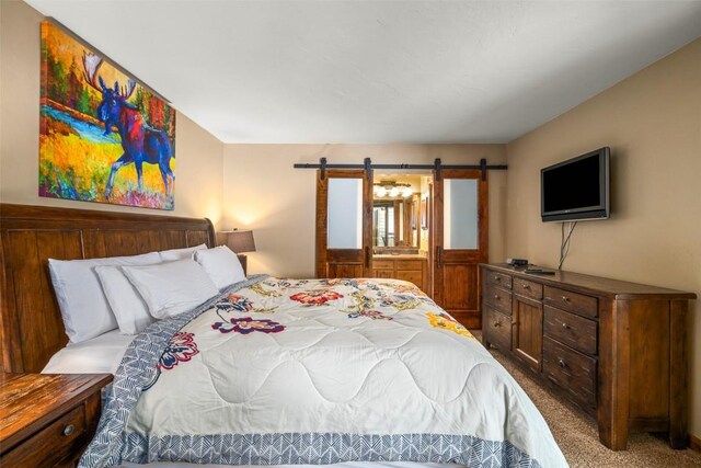 bedroom with carpet and a barn door