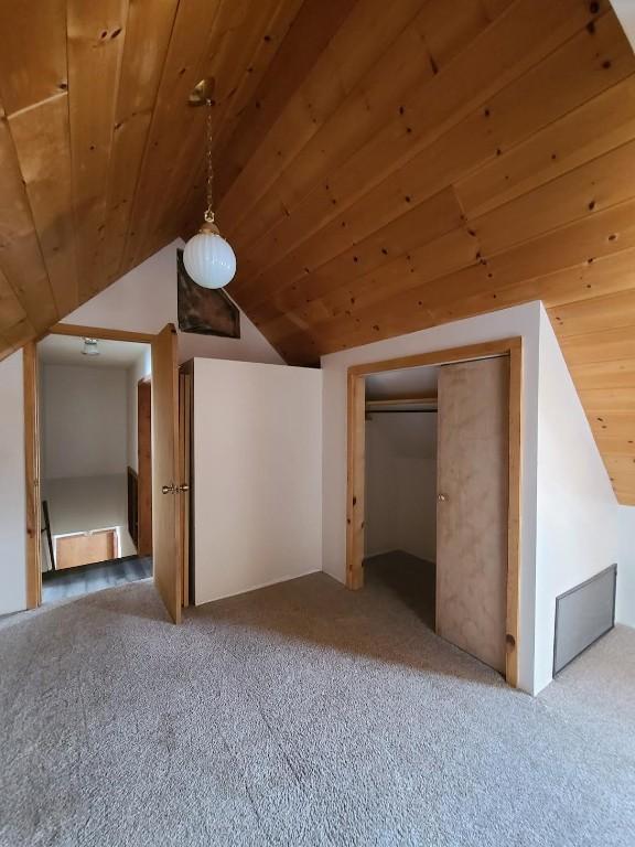 bonus room featuring vaulted ceiling, carpet floors, and wooden ceiling