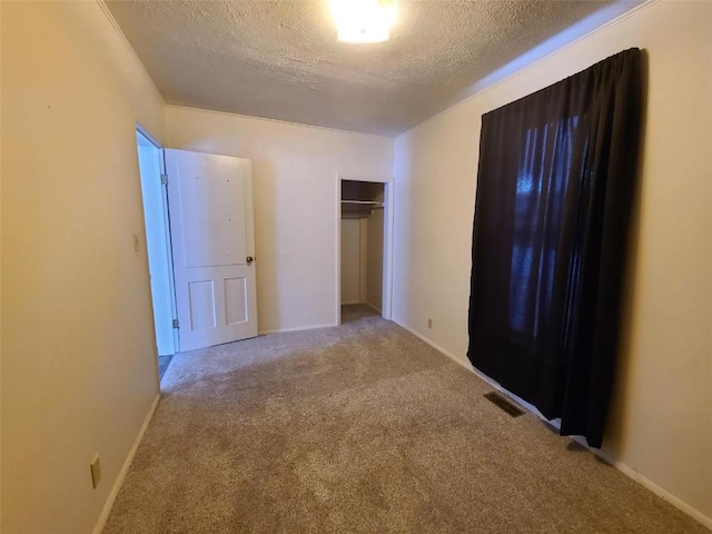 unfurnished bedroom featuring light colored carpet, a closet, and a textured ceiling