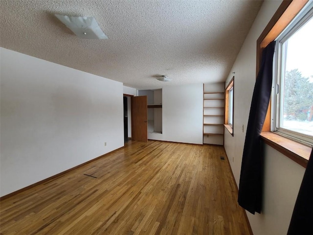 spare room featuring a textured ceiling and light wood-type flooring