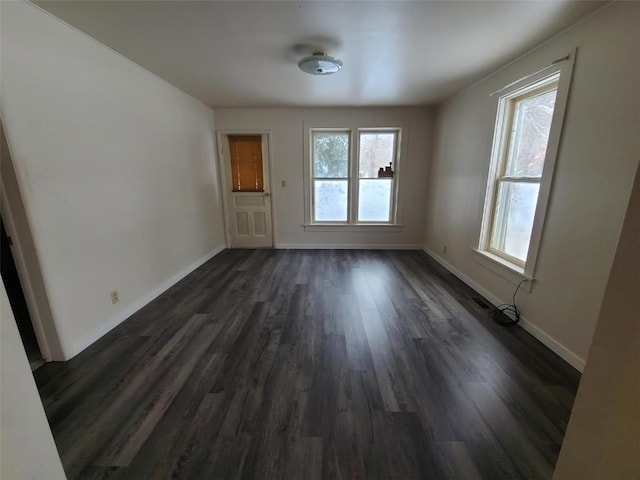 spare room with dark wood-type flooring