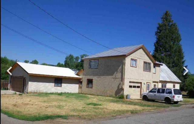 view of property exterior featuring a yard and a garage