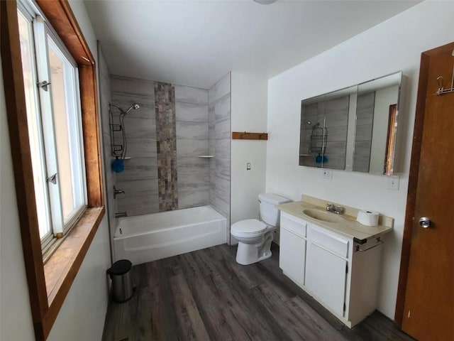 full bathroom featuring hardwood / wood-style flooring, tiled shower / bath, vanity, and toilet