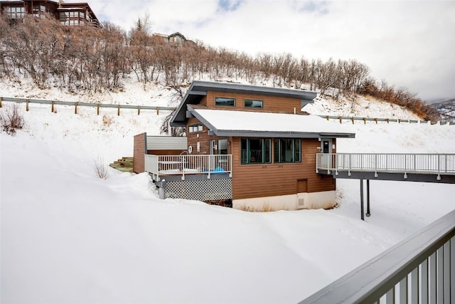 snow covered house with a deck