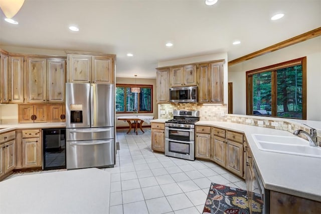 kitchen with sink, wine cooler, ornamental molding, appliances with stainless steel finishes, and tasteful backsplash