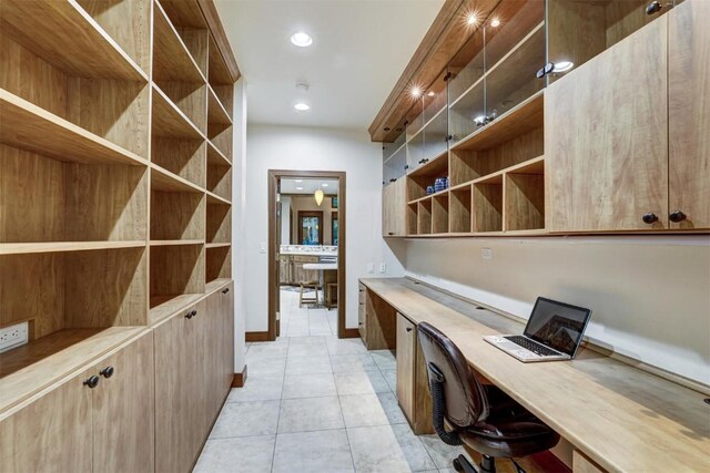 unfurnished office with light tile patterned floors and built in desk