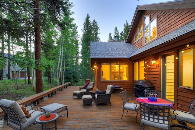 wooden deck with a grill and an outdoor hangout area