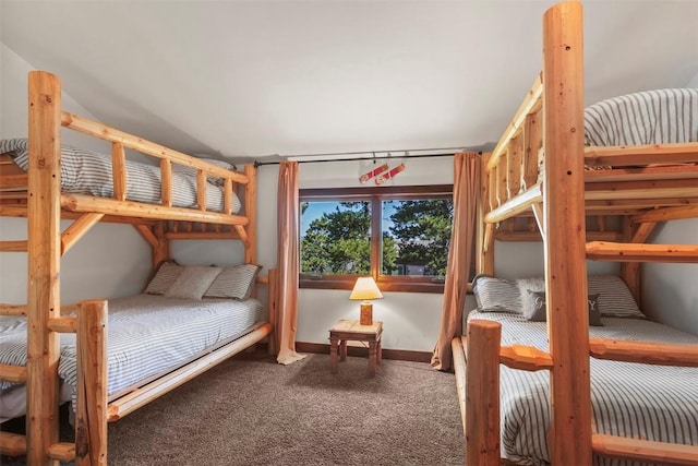 carpeted bedroom with baseboards and vaulted ceiling