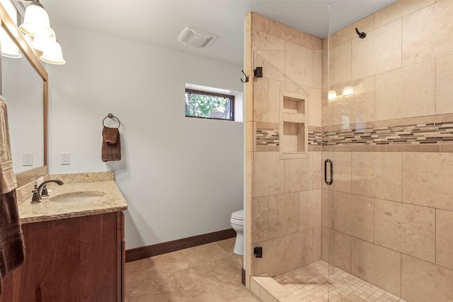 bathroom featuring toilet, visible vents, vanity, baseboards, and a stall shower