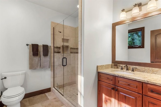 bathroom featuring toilet, a stall shower, baseboards, and vanity