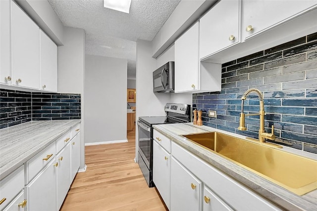 kitchen featuring stainless steel electric stove, light hardwood / wood-style floors, sink, and white cabinets