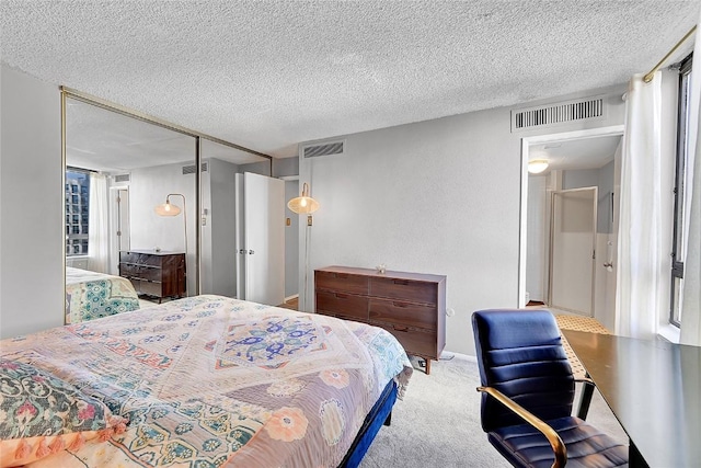 bedroom featuring light carpet, a closet, and a textured ceiling