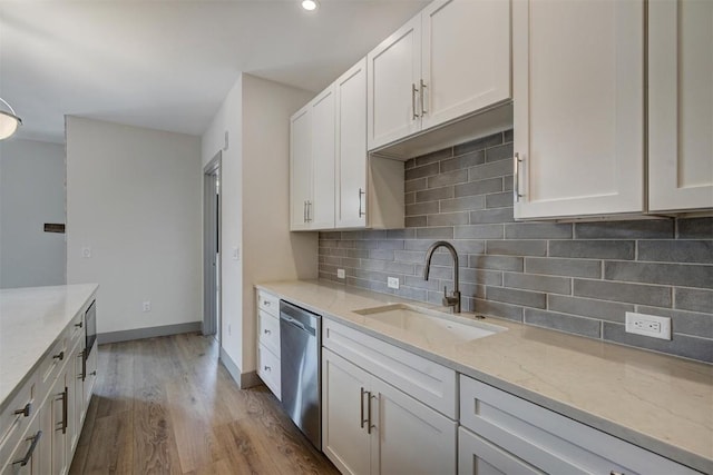 kitchen featuring light stone countertops, light hardwood / wood-style flooring, white cabinetry, and sink