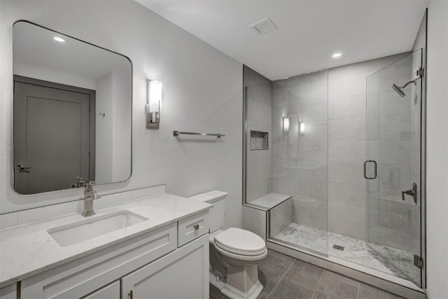 bathroom featuring tile patterned flooring, a shower with door, vanity, and toilet