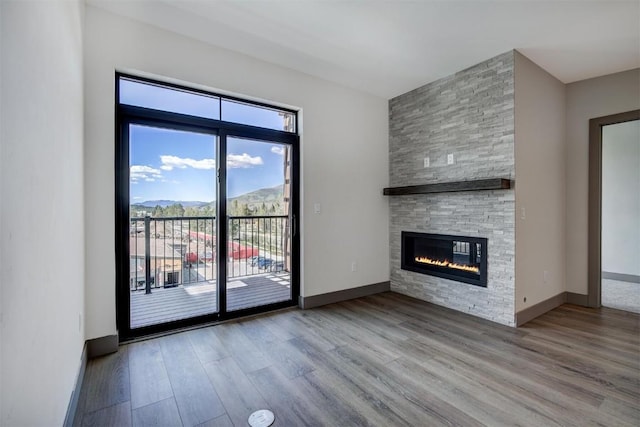 unfurnished living room with a mountain view, wood-type flooring, and a fireplace