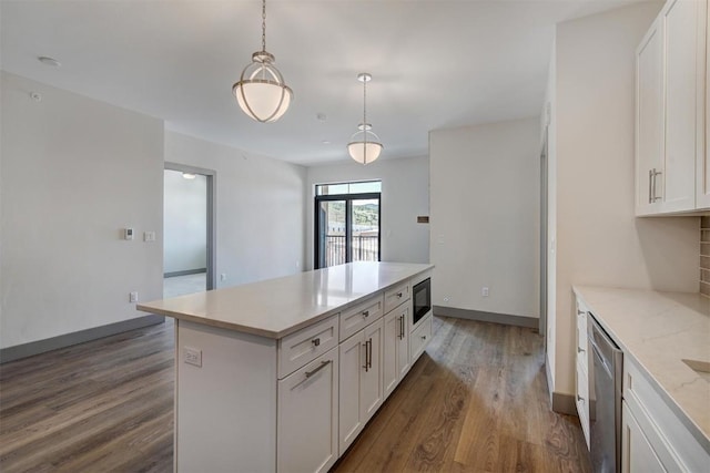 kitchen with black microwave, white cabinetry, a center island, dishwasher, and pendant lighting