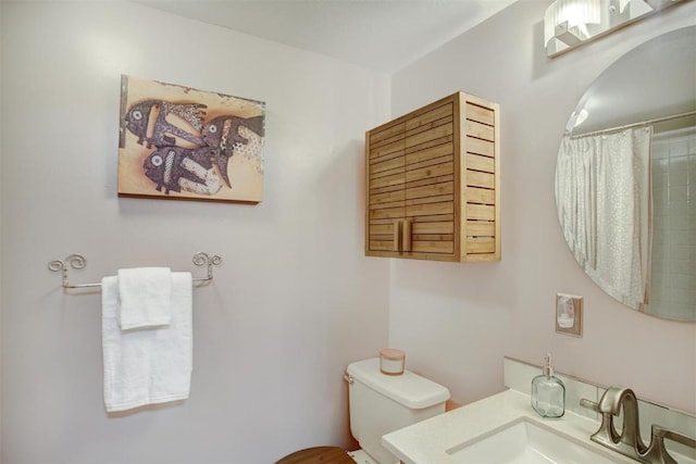 bathroom with vanity, a shower with shower curtain, and toilet