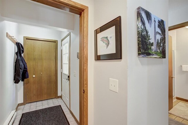 entryway with light tile patterned floors and baseboard heating