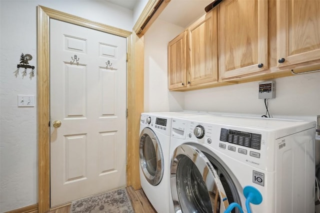 clothes washing area featuring cabinets, hardwood / wood-style floors, and separate washer and dryer