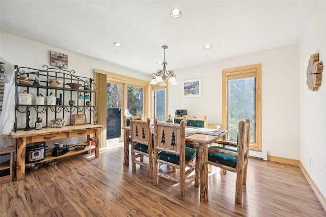 dining space with hardwood / wood-style flooring and an inviting chandelier