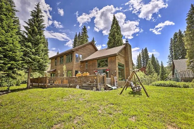 back of house with a lawn and a deck