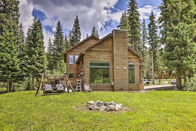 rear view of property featuring a yard and a deck