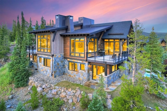 back house at dusk with a balcony