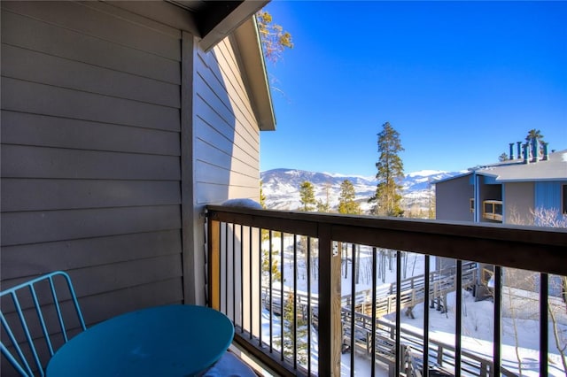 snow covered back of property with a mountain view