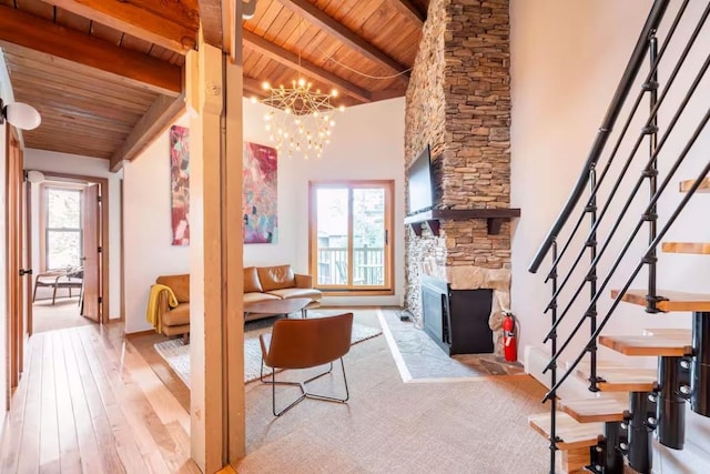 living room featuring beam ceiling, a chandelier, a fireplace, and wood ceiling