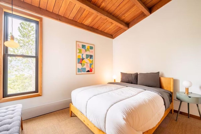 bedroom with vaulted ceiling with beams, wooden ceiling, and carpet