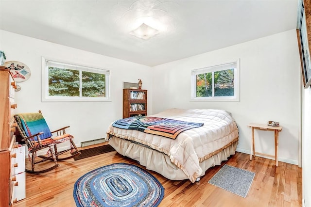 bedroom featuring hardwood / wood-style floors and baseboard heating