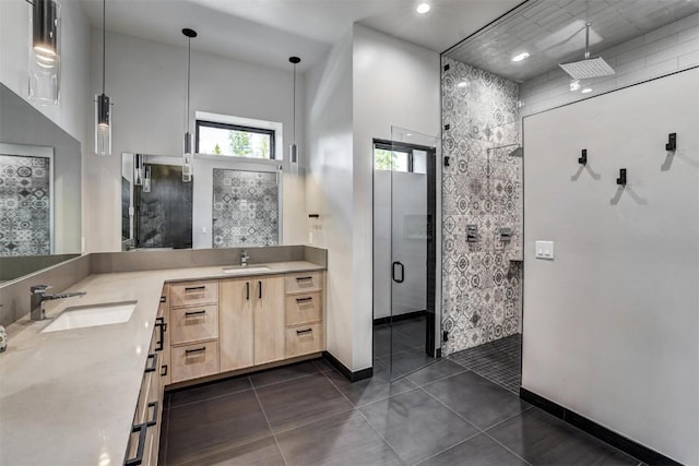 bathroom with tile patterned flooring, vanity, and walk in shower