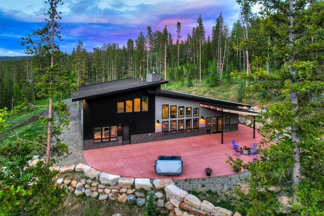 back house at dusk with a bar and a patio