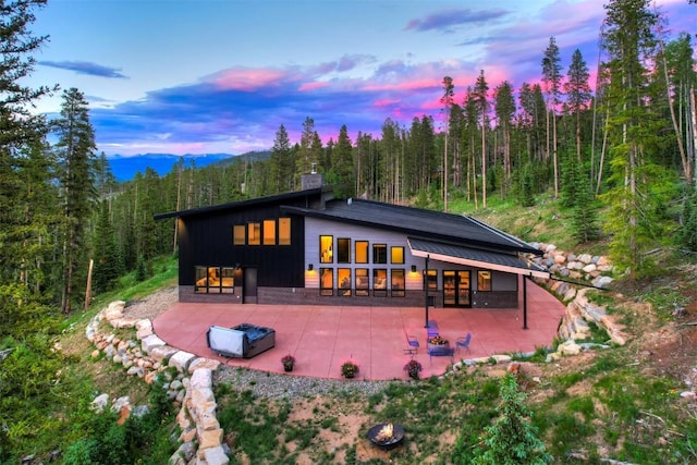 back house at dusk with a patio