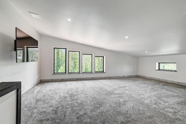 carpeted empty room featuring plenty of natural light and lofted ceiling