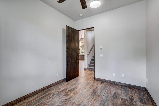 empty room with ceiling fan and wood-type flooring