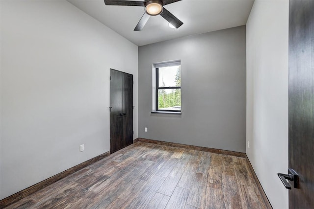 spare room with ceiling fan and dark wood-type flooring