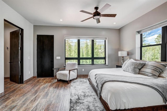 bedroom featuring multiple windows, ceiling fan, and dark wood-type flooring