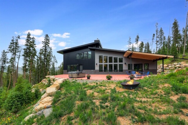 back of property featuring a patio and an outdoor fire pit