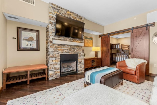 living room with dark wood-type flooring, a barn door, and a fireplace