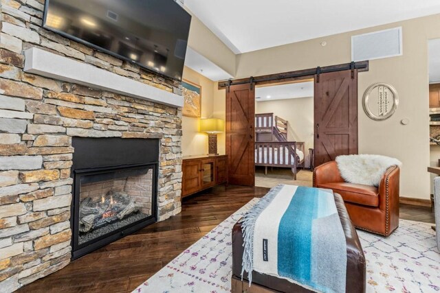 interior space with a fireplace, a barn door, and hardwood / wood-style floors