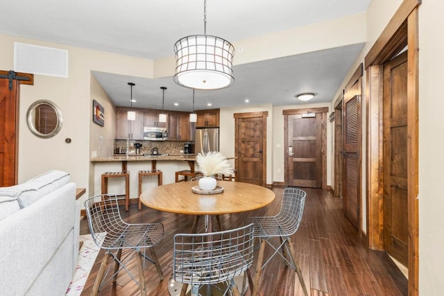 dining room featuring dark wood-type flooring and a barn door