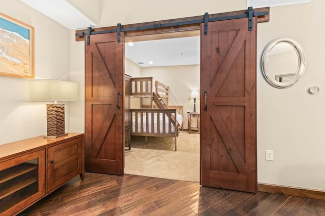 hall featuring a barn door and dark hardwood / wood-style flooring